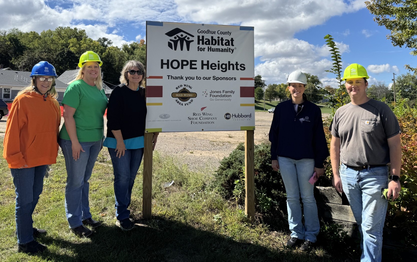 Group of employees posing in front of Habitat for Humanity sign